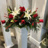 This centerpiece with beautiful red roses, white lilies and red berries is