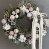 This luxurious winter wreath is crafted from fresh evergreens and adorned with