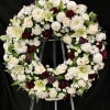 A timeless and graceful tribute in ivory and burgundy.
This standing wreath features