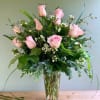 This elegant vase features a beautiful arrangement of pink roses and delicate