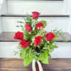 7 red roses in a vase with eucalyptus and wax flowers 