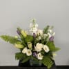 A white arrangement with subtle touches of green and purple. An elegant