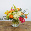 This arrangement is presented in a pinched glass vase and accented by