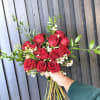 A bouquet of 12 long stemmed roses, in classic red, with sprigs
