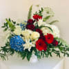 A large free-flowing arrangement of red, white, and blue in a white