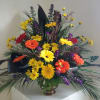 Reds, oranges, yellows and purple artfully arranged in a copper color urn