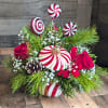 Shown as Standard
Red roses, babies breath, sparkly evergreens, and pinecones comes arranged