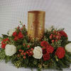 Gold ensconced tea candle surrounded by red and white roses with berries