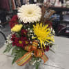 A stunning autumn-inspired floral creation perfectly crafted in a container 