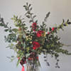 This arrangement presents a glorious array of peaceful holly, holiday evergreens, and