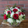 Bubble bowl filled with fluffy white hydrangeas, red roses, red anemones, green