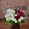 Festive holiday small centerpiece bouquet in a ruby red square vase filled
