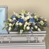 Casket Spray in white and blue with hydrangeas, lilies, delphinium, snaps, roses