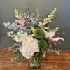 Beautiful floral arrangement in a clear vase with lilies, hydrangeas, snapdragon, green