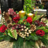 Roses, Cymbidium orchids, Gold candles and accents, Christmas greens and decorations. 