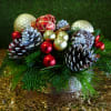 Festive holiday greens atop a beautiful silver container with pinecones and ornaments.
