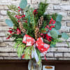 A festive floral arrangement that exudes natural charm, featuring vibrant red berries