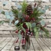 A stunning arrangement of mixed evergreen with berry stems artfully displayed in