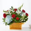 This arrangement features a patriotic display of blue, red and white florals.