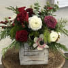 A pretty arrangement consisting of red berries, white anemone, red roses, white