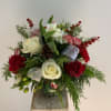 A beautiful clear globe of CHRISTMAS blooms including roses, carnations, ornaments and