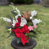 A deluxe arrangement jn classic holiday colors with baubles and a red