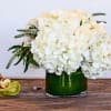 Clean white hydrangea accented by crisp white florals in a leaf wrapped