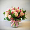 A tender embrace of blush pink roses and tulips, this bouquet captures