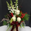A tall birch vase filled with a handsome assortment of winter greens