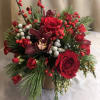 A decadent floral display of seasonal red toned floral blossoms designed with