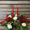 Rose centerpiece with candles. Red and white roses and seasonal greens arranged