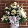 A festive all white arrangement with white roses, spider mums, carnations, stock