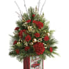 Evoking a festive Christmas tree, this stunning seasonal arrangement is presented in