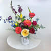 This arrangement bursts with vibrant, rainbow-hued flowers, symbolizing love, diversity, and inclusivity.