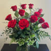Arrangement of a dozen red roses in a vase.
