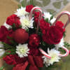 A holiday bouquet with assorted seasonal blooms, ornaments ad candy canes