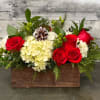 A beautiful holiday centerpiece in a birch box, including white hydrangea, red