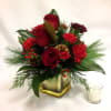 Roses, Carnations and hypericum berries are set in winter greens with pine