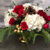 Red roses, white hydrangea, green hypericum, winter greens and magnolia in a