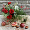 Bounties of evergreens, berries, and blooms make this lovely arrangement the perfect
