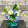 Blue Hydrangea, white roses, white stock and white tulips in a turquoise