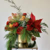 A festive holiday flower centerpiece with premium flowers designed in a gold