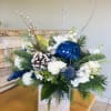 An elegant Christmas centerpiece in silver royal blue and white colors. White