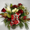 Vased arrangement filled with festive blooms and traditional poinsettia accents.