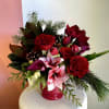 Created in a red compote vase,  with red amaryllis, red roses
