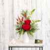 Petite and sweet, a modern white vase is filled with evergreens, red