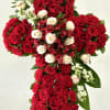 A beautifully crafted floral cross featuring lush red roses symbolizing deep love