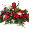 A charming Christmas table arrangement with a single tapered candle, accented by
