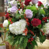 This large vase is filled with premium assorted evergreens, berries and assorted