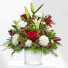 This unique holiday design includes lilies, roses, cremones, carnations, holiday greens and
